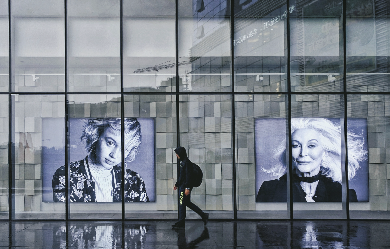A man walking next to ad posters