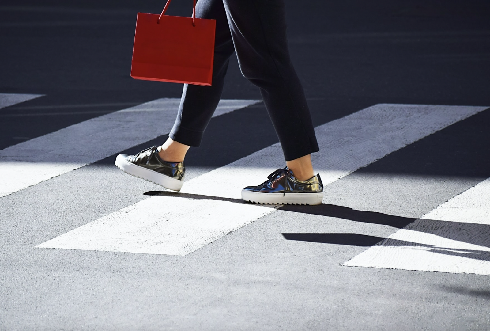 Woman walking across the street with shopping bag