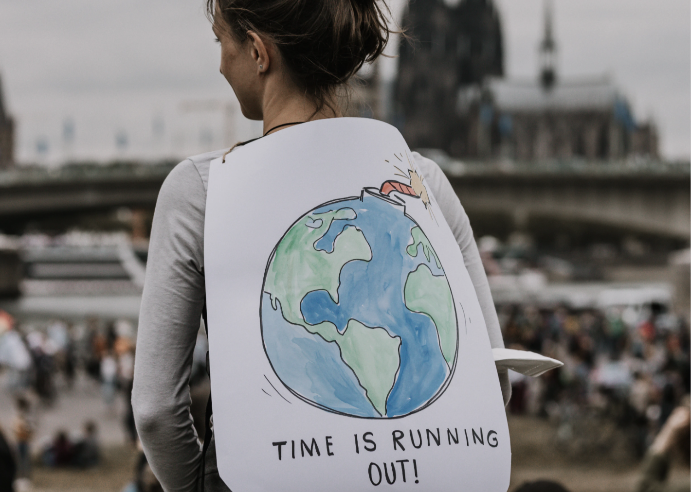 Woman with a sign that says "Time is Running Out"