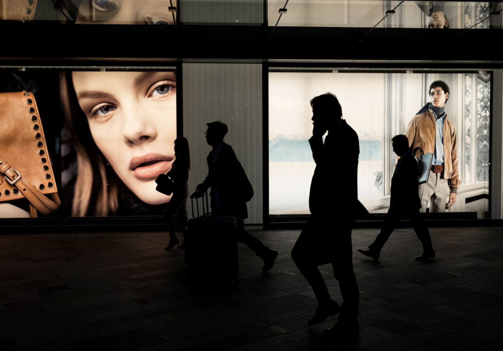 People walking in front of fashion advertising